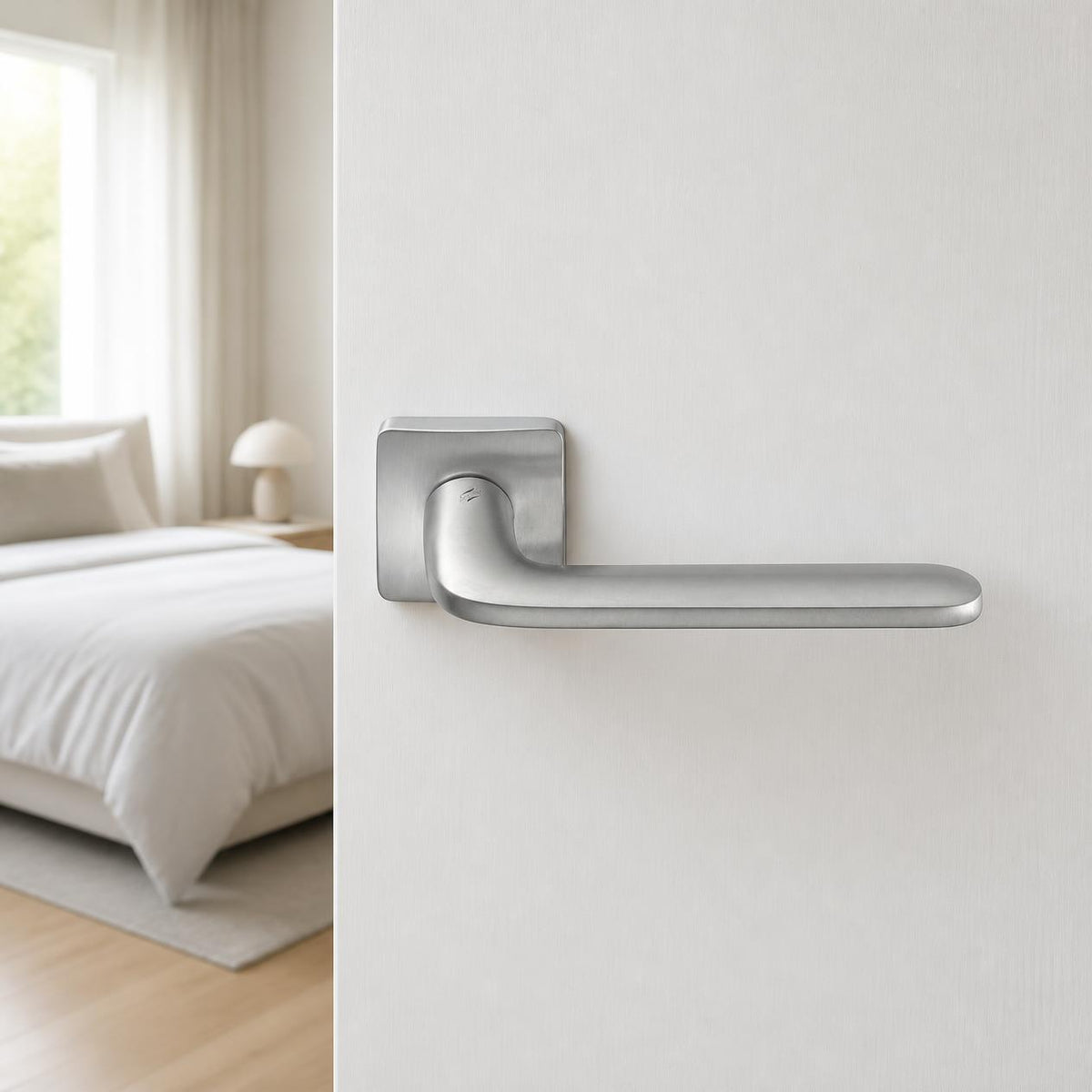 Fedra Italian lever handle on rose on a white timber door ajar to a modern bedroom