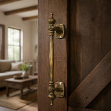 Antique brass offset pull handle with finials on an oak sliding door