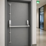 Emergency exit push bar with vertical bolts on a grey fire exit door