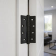 Matt black butt hinge 100x75mm on a white interior door